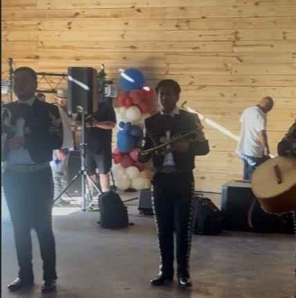 Músicos de traje charro tocando en el granero